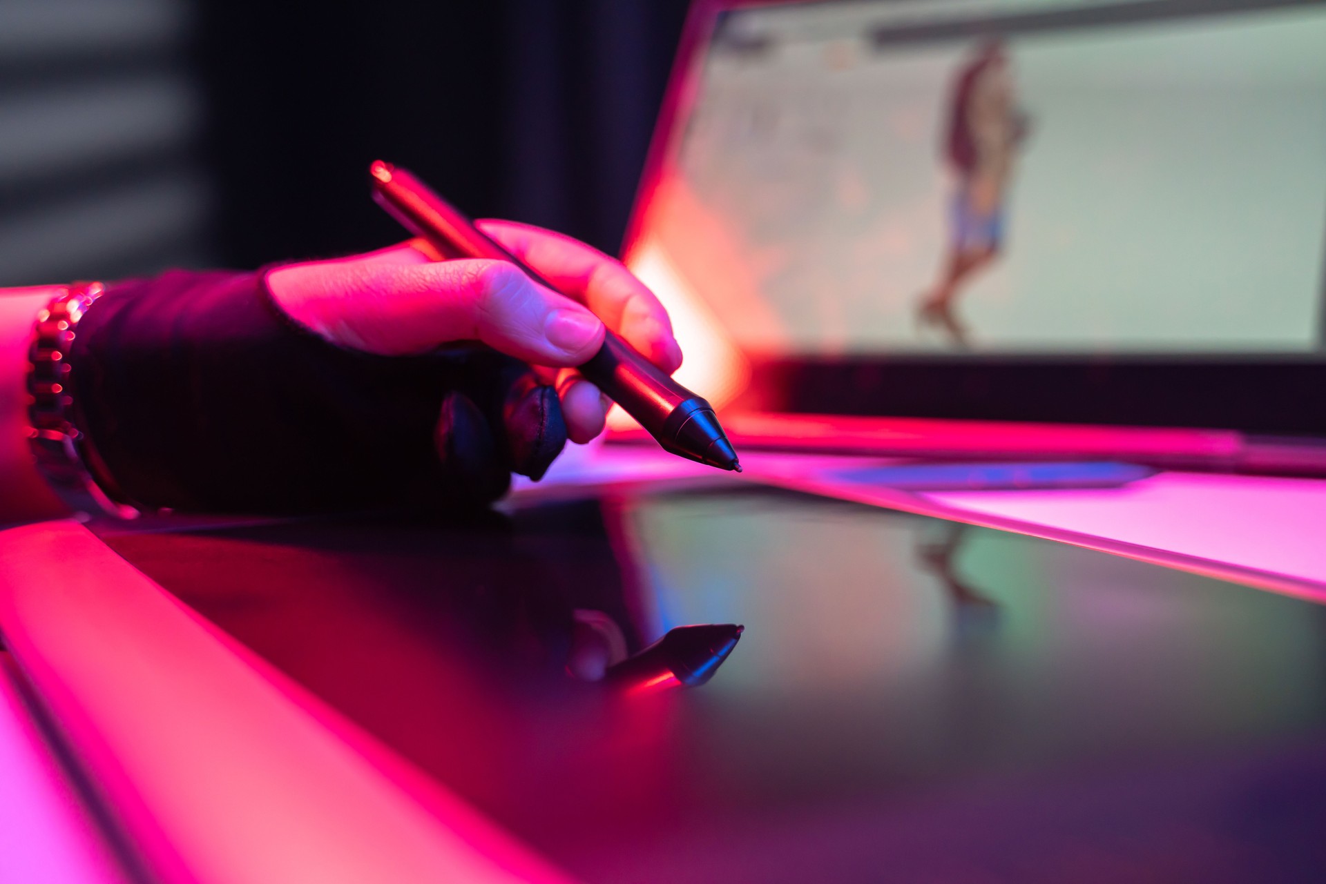 Young woman illustrator graphics designer holding digital pen over tablet and laptop